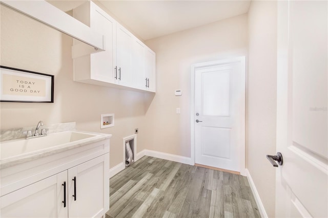 washroom with hookup for a washing machine, sink, cabinets, light wood-type flooring, and electric dryer hookup