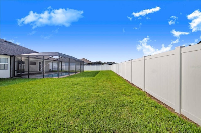 view of yard with glass enclosure and a swimming pool