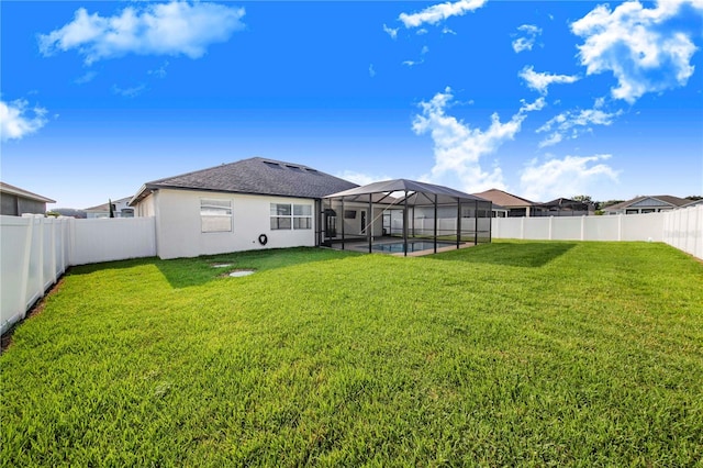 view of yard with a pool and glass enclosure