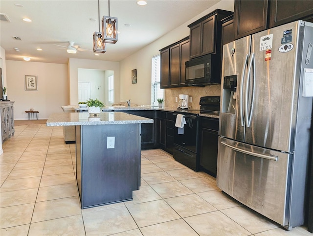 kitchen featuring ceiling fan, decorative backsplash, hanging light fixtures, a breakfast bar area, and black appliances