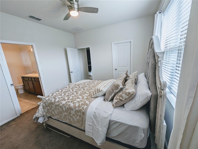 bedroom with ceiling fan, carpet flooring, connected bathroom, and multiple windows