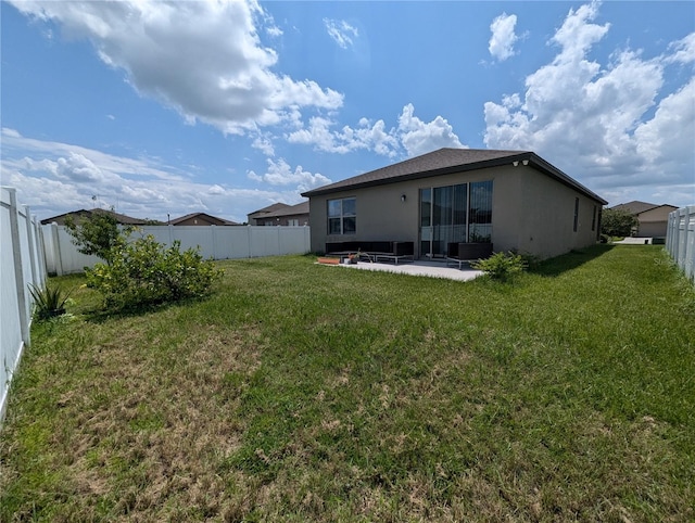 back of house with a patio and a yard