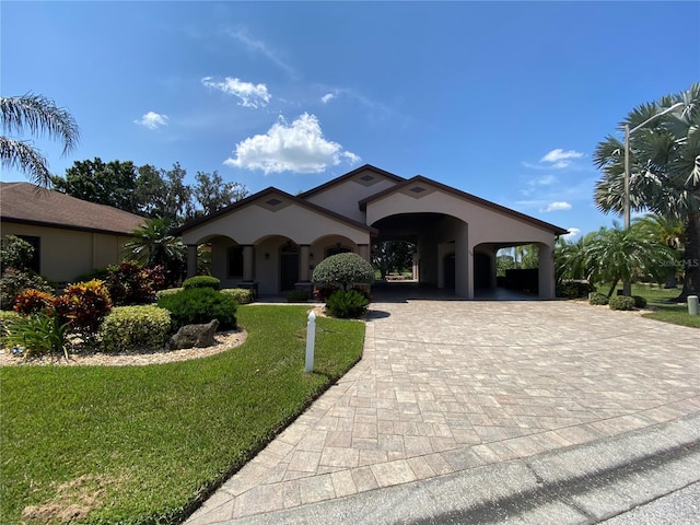 mediterranean / spanish home featuring a carport and a front yard