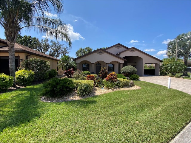 mediterranean / spanish house featuring a carport and a front lawn