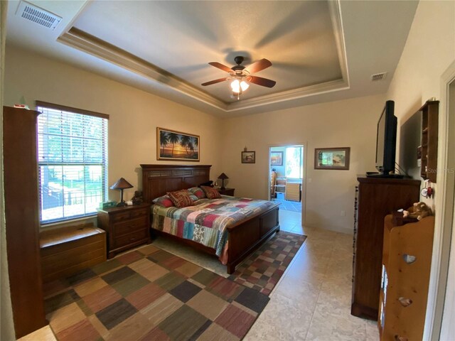 bedroom with a raised ceiling, tile patterned floors, and multiple windows