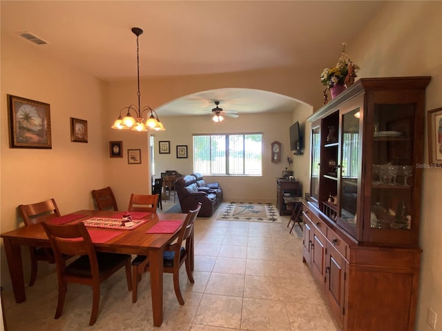 tiled dining space featuring ceiling fan with notable chandelier