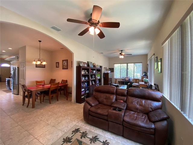 living room with ceiling fan with notable chandelier and light tile patterned floors