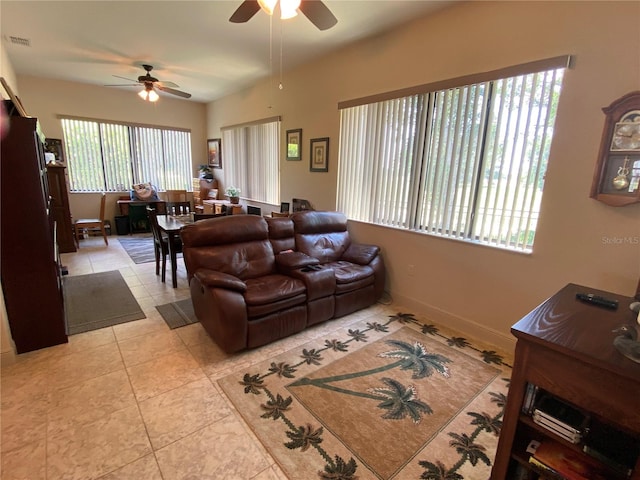 living room featuring ceiling fan, light tile patterned flooring, and a wealth of natural light