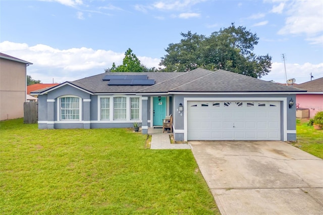 single story home with a front lawn, solar panels, and a garage