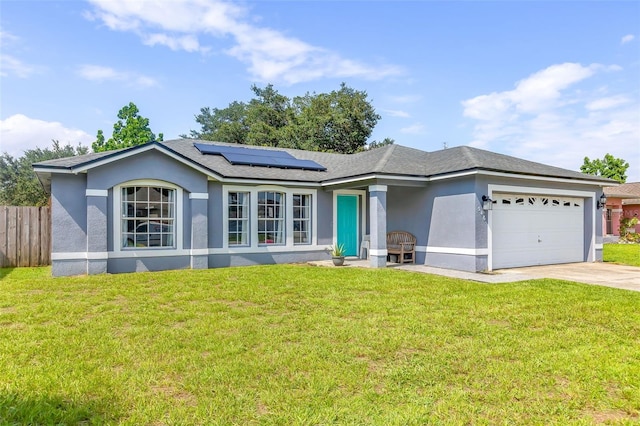 ranch-style house with a garage, solar panels, and a front yard