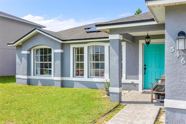 doorway to property featuring a lawn