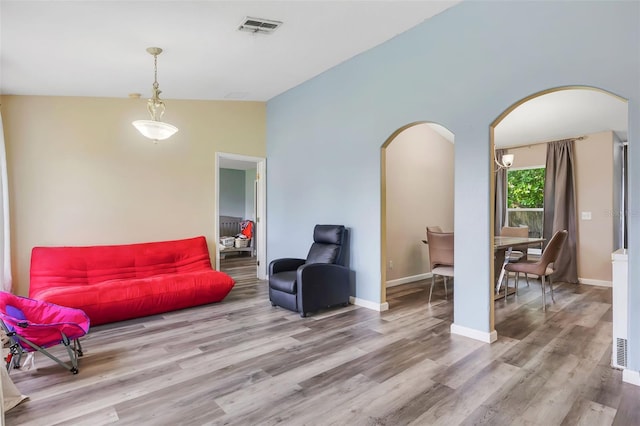 living area with high vaulted ceiling and hardwood / wood-style floors