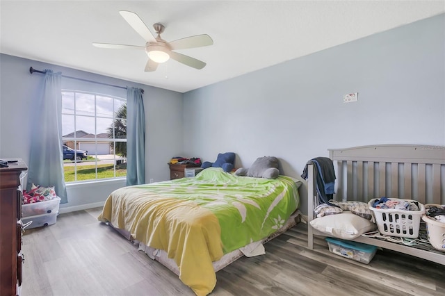 bedroom with light hardwood / wood-style flooring and ceiling fan