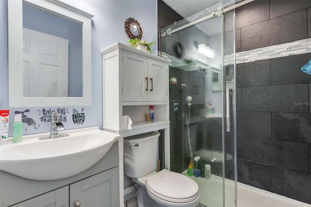 bathroom with an enclosed shower, vanity, and toilet