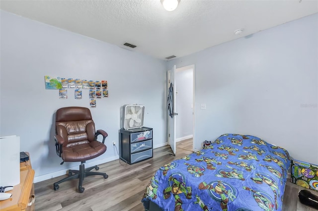 bedroom featuring a textured ceiling and hardwood / wood-style floors