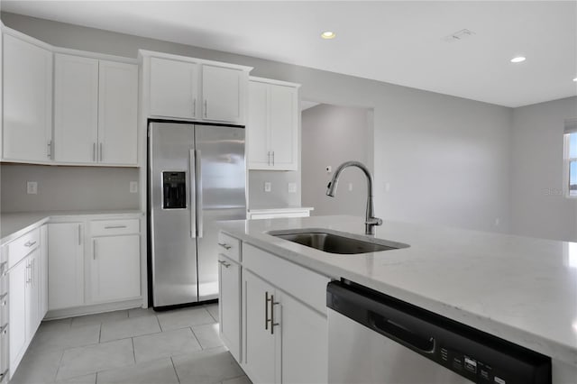 kitchen featuring white cabinets, stainless steel appliances, light stone counters, and sink