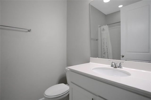 bathroom featuring walk in shower, vanity, and toilet