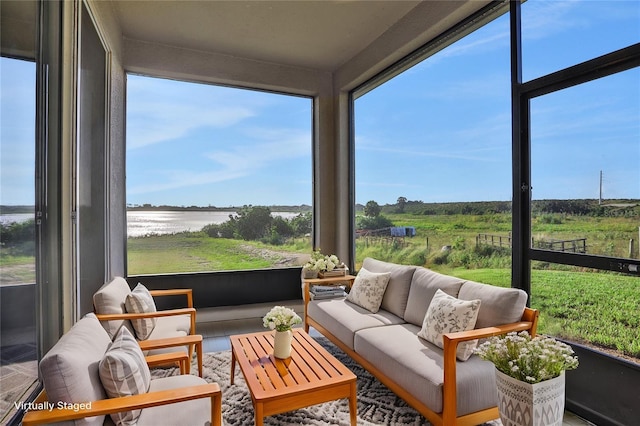 sunroom featuring plenty of natural light and a water view