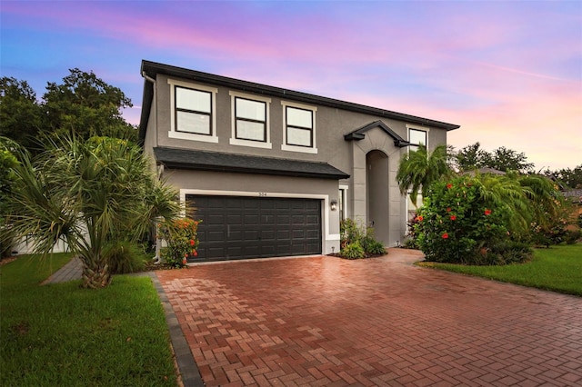 view of front of property featuring a garage and a lawn