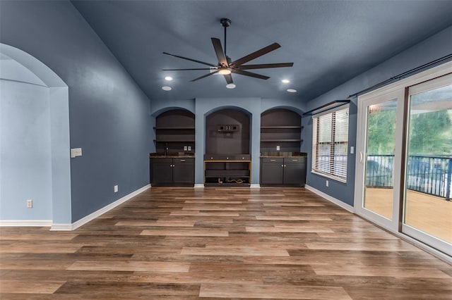 unfurnished living room featuring lofted ceiling, wood-type flooring, and ceiling fan