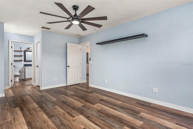 unfurnished bedroom featuring dark hardwood / wood-style floors, ensuite bathroom, and ceiling fan