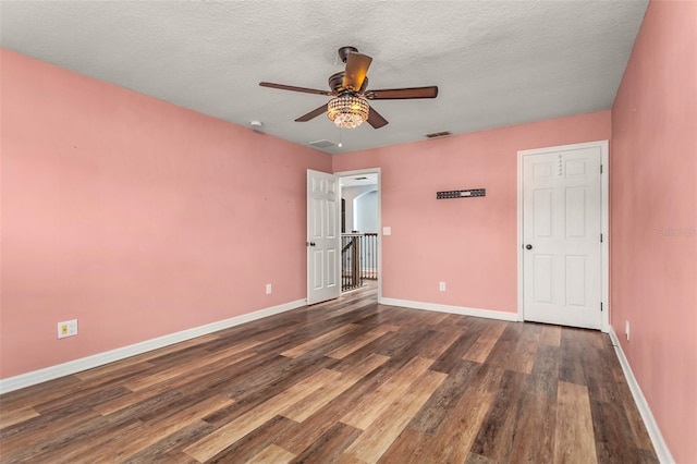 unfurnished bedroom featuring dark wood-type flooring, ceiling fan, and a textured ceiling