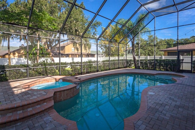 view of pool with an in ground hot tub, a patio area, and a lanai