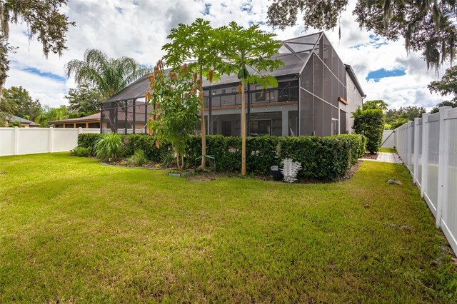 rear view of property with a lanai and a yard