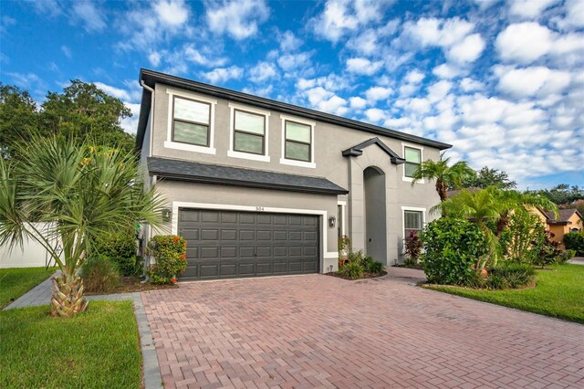 view of front of property featuring a front lawn and a garage