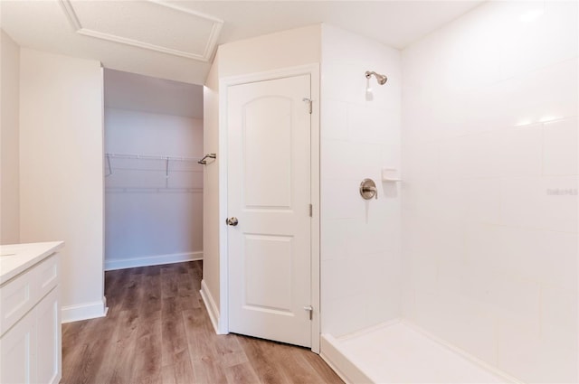 bathroom with walk in shower, vanity, and hardwood / wood-style floors