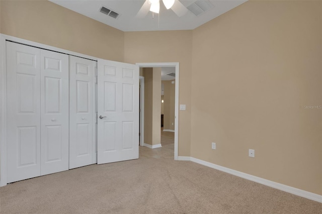 unfurnished bedroom with light carpet, a closet, and ceiling fan