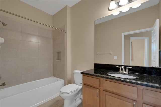 full bathroom featuring tiled shower / bath combo, vanity, and toilet