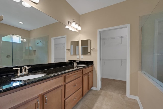 bathroom with walk in shower, tile patterned flooring, and vanity