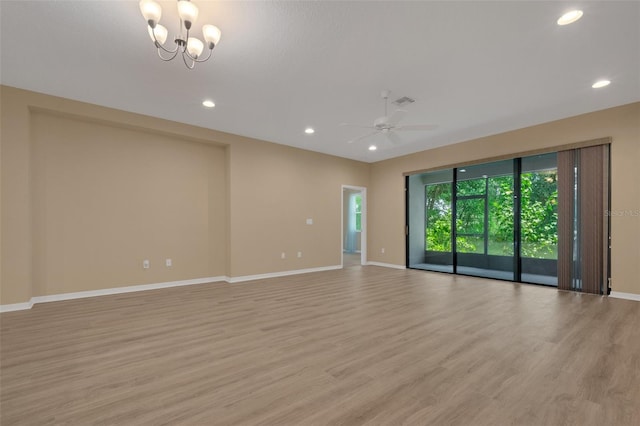 unfurnished room featuring ceiling fan with notable chandelier and light hardwood / wood-style floors