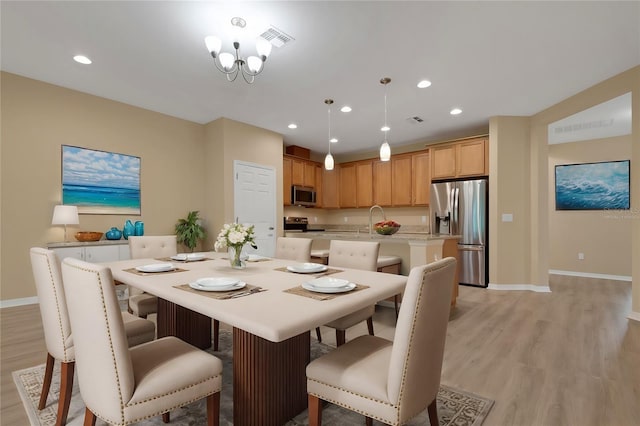 dining space featuring light hardwood / wood-style flooring and sink