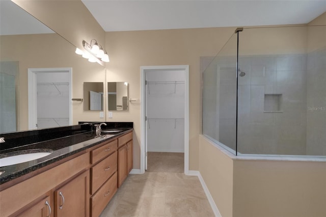 bathroom with a tile shower and vanity