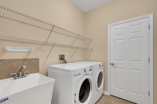 laundry area with light tile patterned floors, sink, and independent washer and dryer