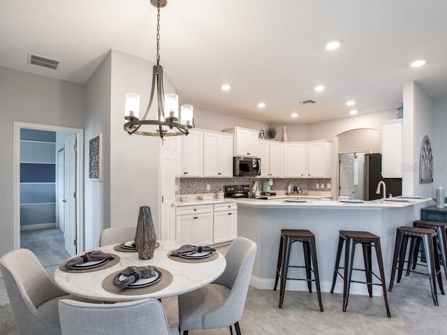 tiled dining area with sink and a notable chandelier