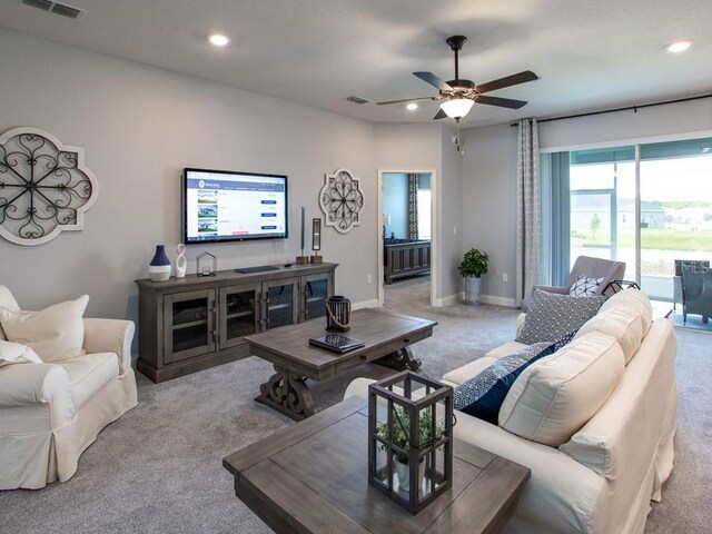 carpeted living room with ceiling fan