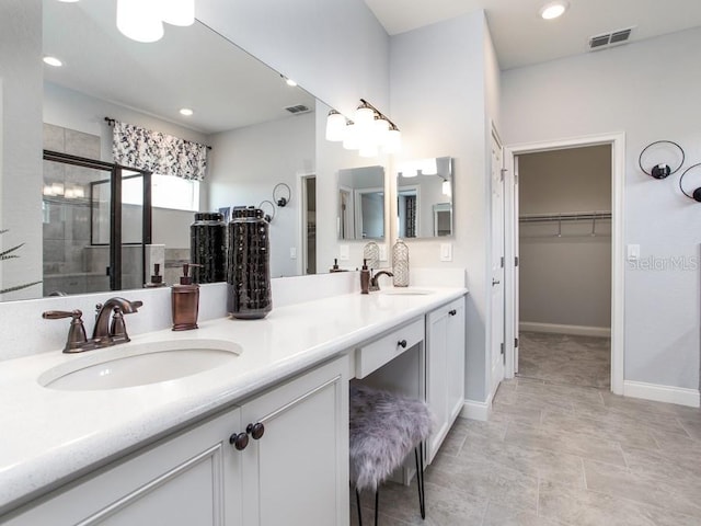 bathroom with tile patterned flooring, an enclosed shower, and double vanity