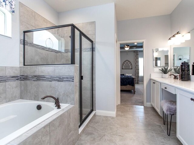 bathroom featuring ceiling fan, vanity, a healthy amount of sunlight, and shower with separate bathtub