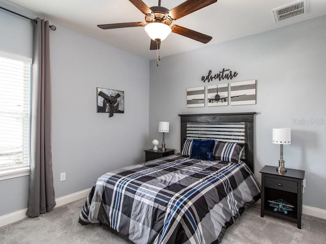 carpeted bedroom with ceiling fan and multiple windows