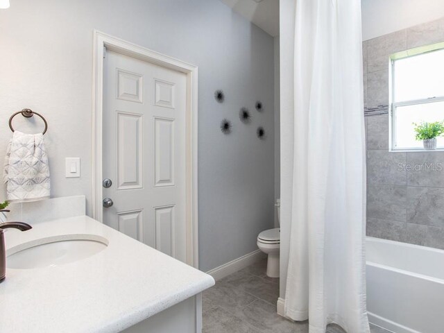 full bathroom featuring tile patterned flooring, vanity, shower / tub combo with curtain, and toilet