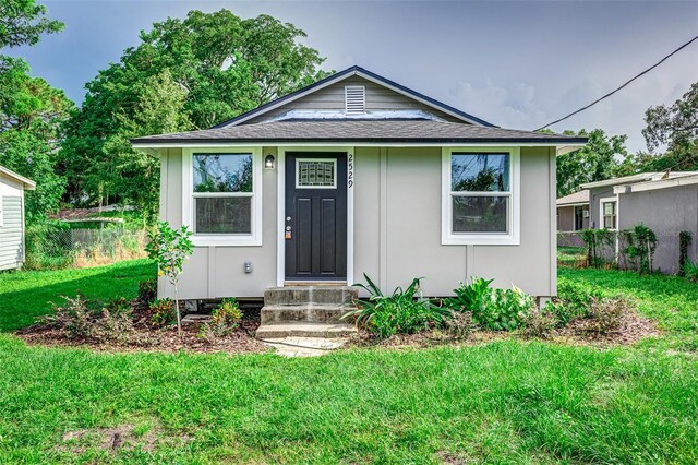 bungalow-style house featuring a front lawn