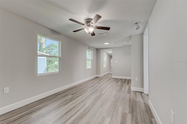 unfurnished room featuring ceiling fan, light wood-type flooring, and a textured ceiling