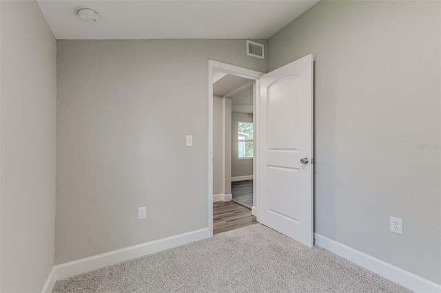 empty room featuring carpet flooring and vaulted ceiling