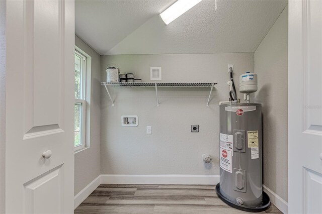 laundry room with hookup for a washing machine, wood-type flooring, hookup for an electric dryer, a textured ceiling, and electric water heater