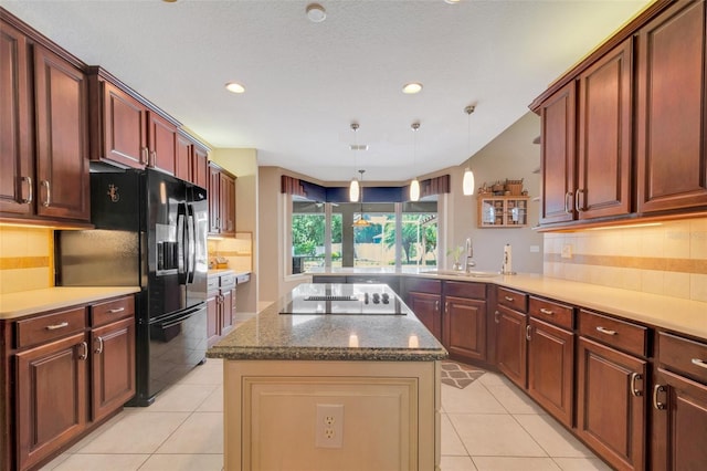 kitchen featuring black appliances, pendant lighting, a center island, sink, and kitchen peninsula