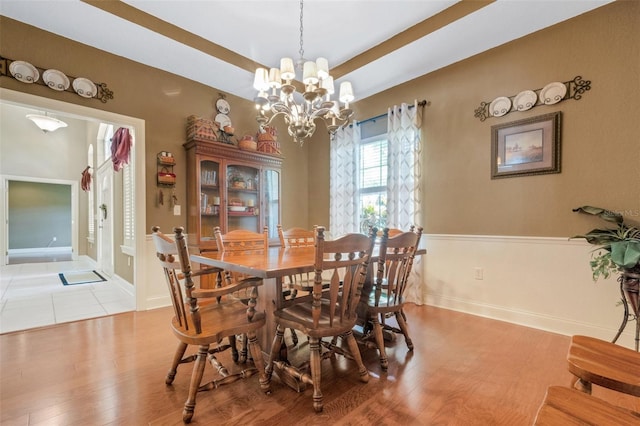 dining room with light hardwood / wood-style flooring and a chandelier