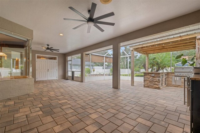 view of patio with area for grilling, ceiling fan, and a lanai